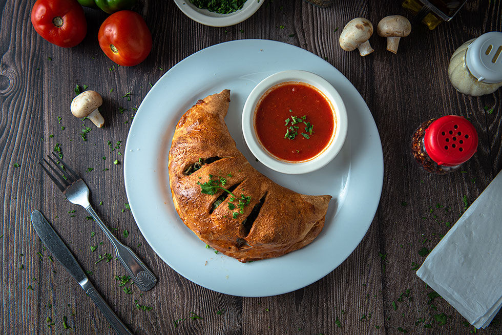 calzone on a dish with sauce