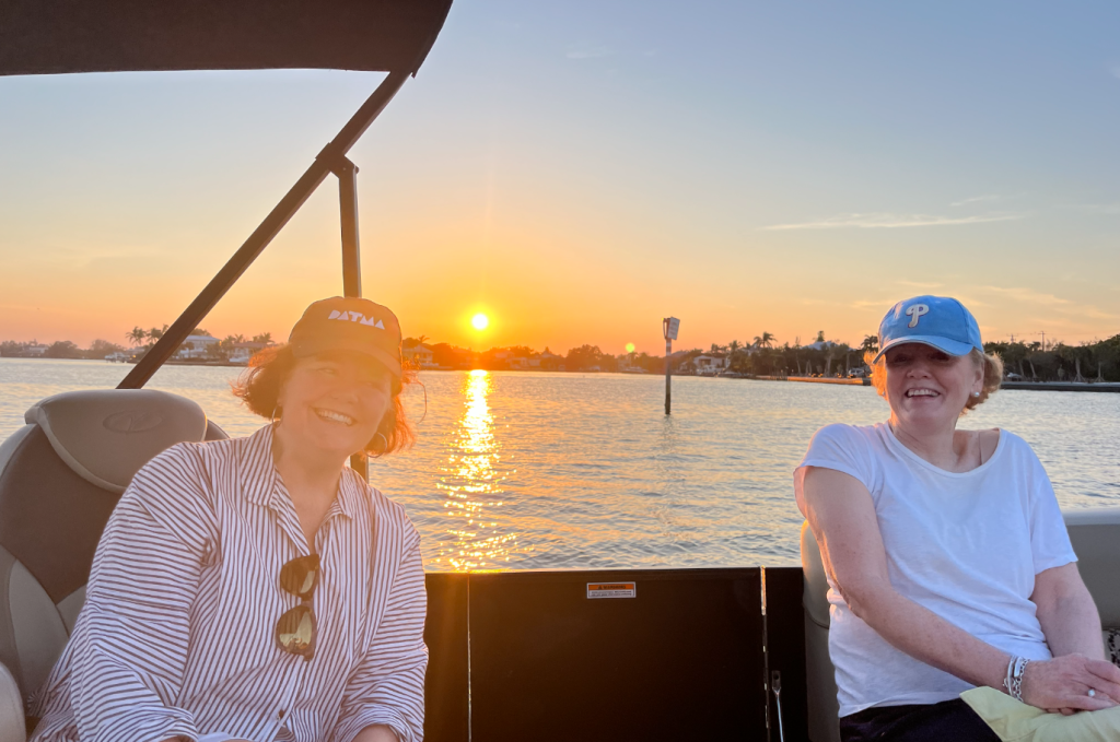 two women on a boat at sunset