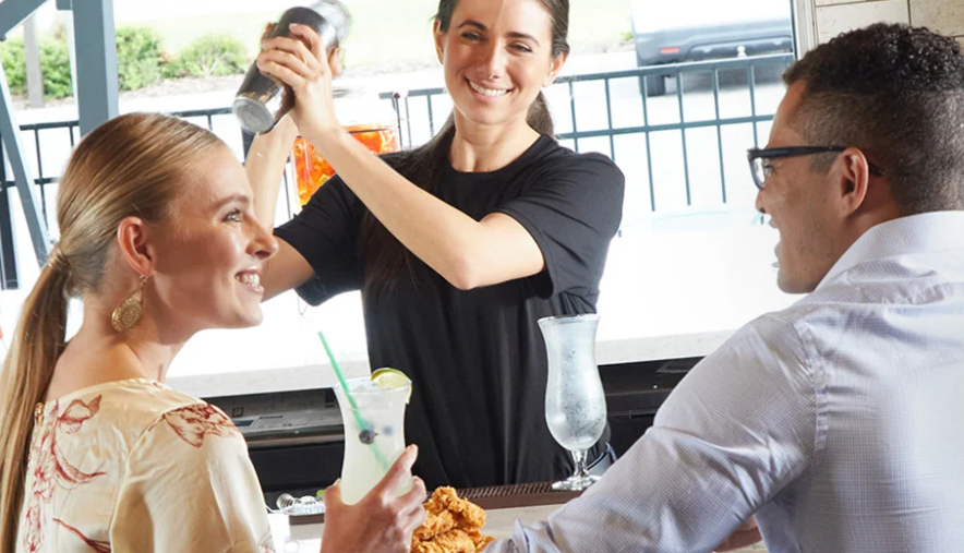 couple at cafe bar with barista making drink