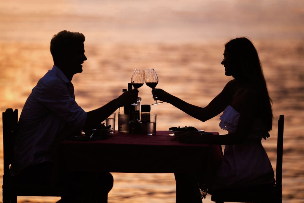couple toasting glasses at sunset